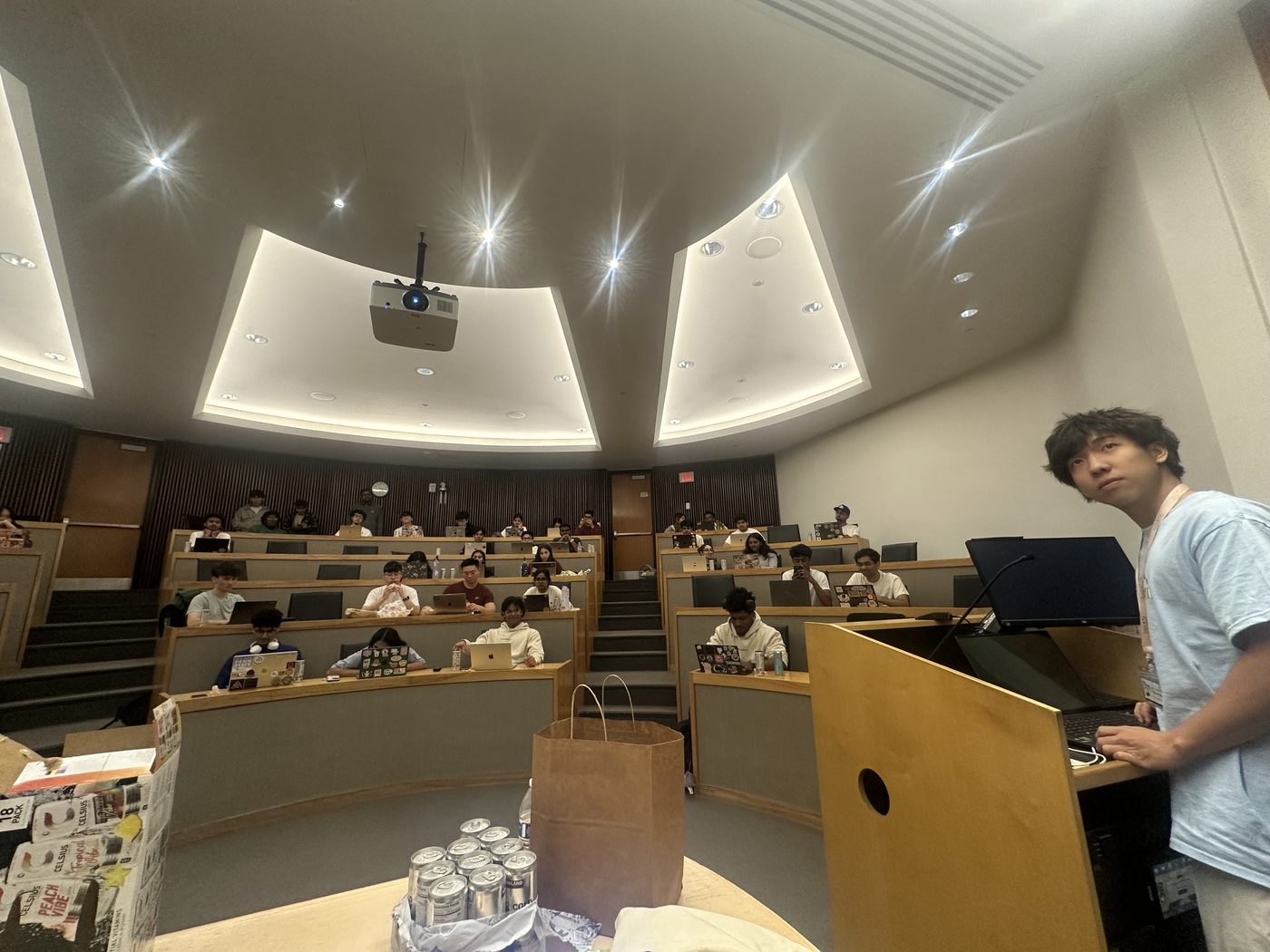 Jimmy at a lectern in a lecture hall, running a hackathon workshop