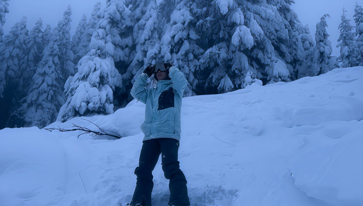 Jimmy snowboarding among snow-covered pines outside Seattle