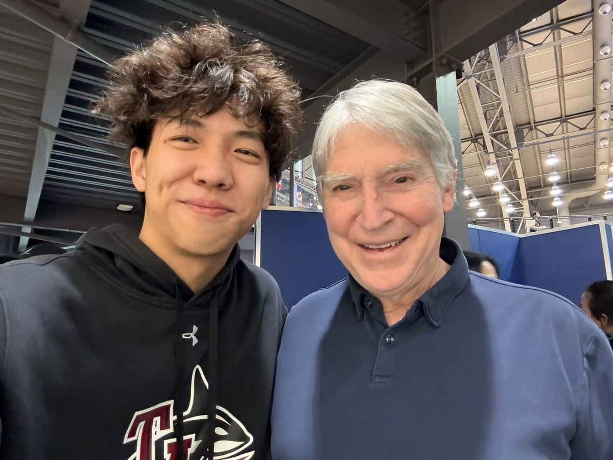 Jimmy smiling beside his squash coach
